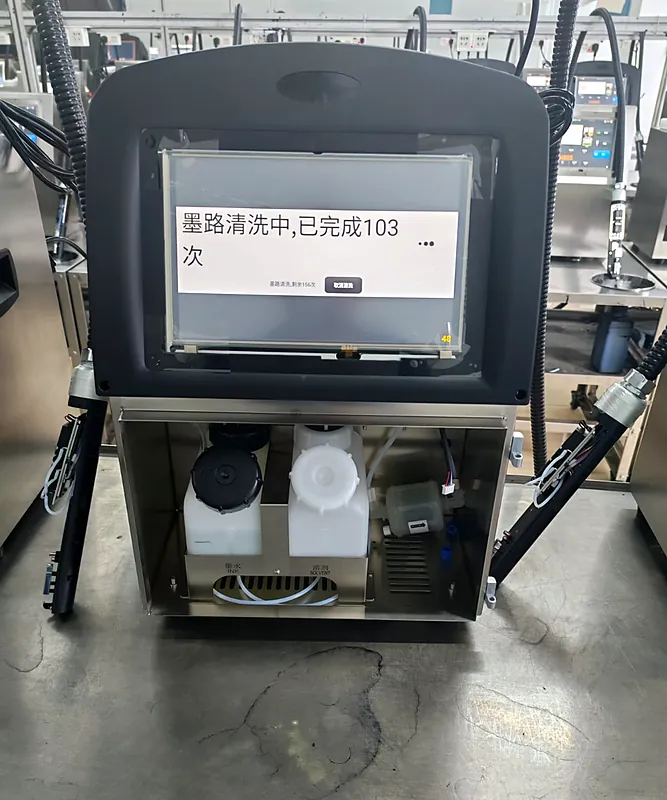 Codificadora abierta durante la prueba de lavado del circuito, con los depósitos de tinta y solvente a la vista